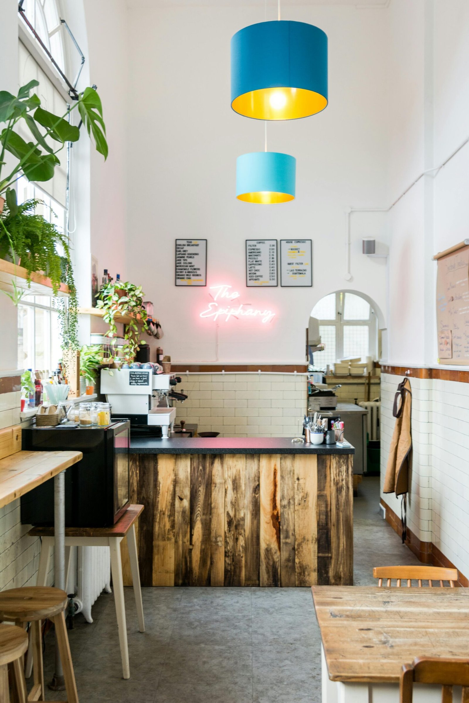 Charming cafe interior with wooden accents, plants, and neon lighting.